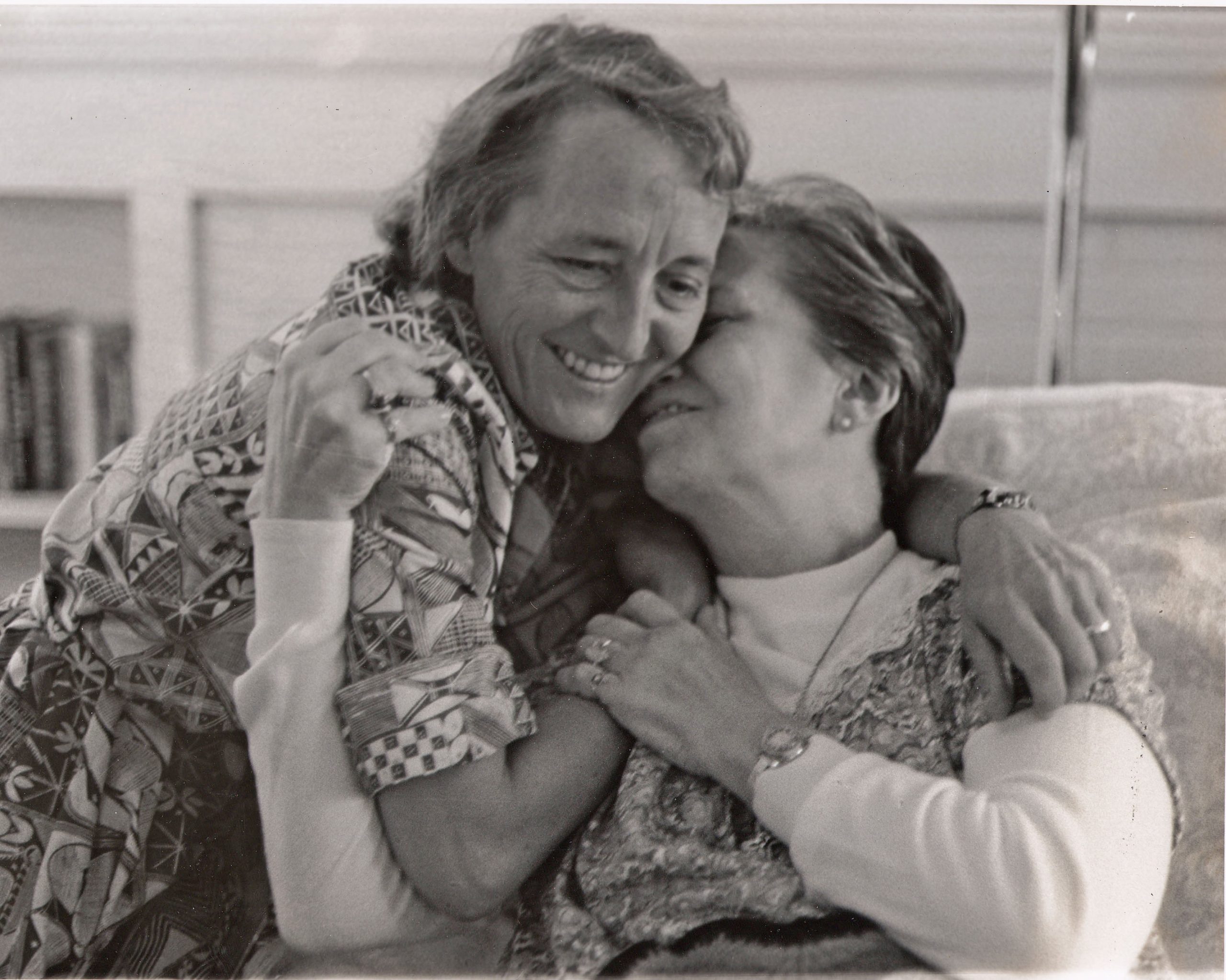 Elisabeth Kübler-Ross embracing a woman, both smiling, in a black-and-white photograph